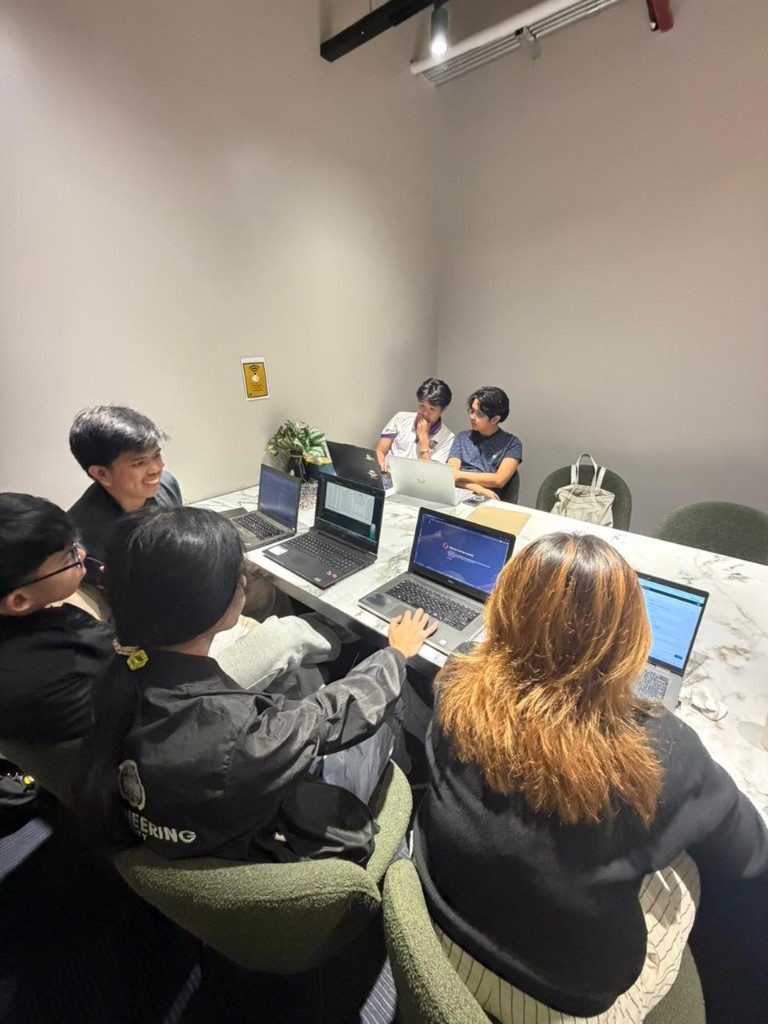 Interns collaborating around laptops during a team session