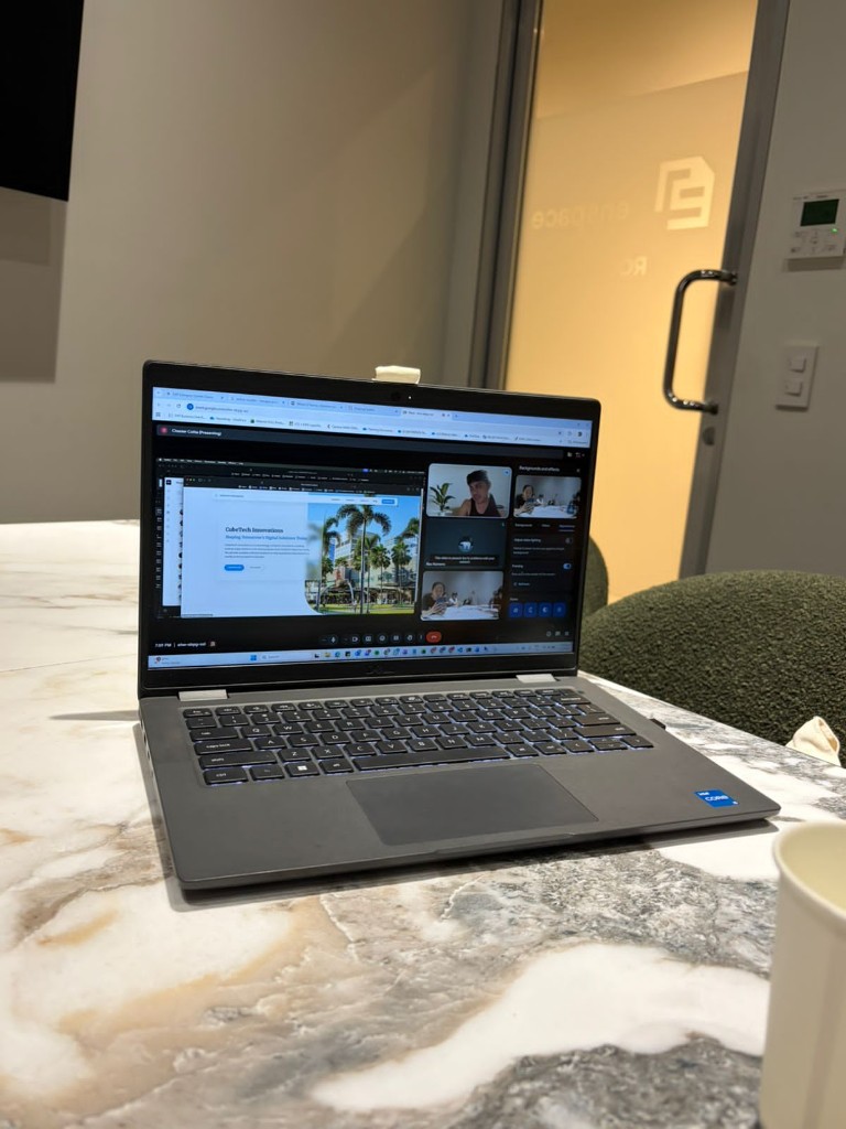 Interns reviewing code together on a shared laptop